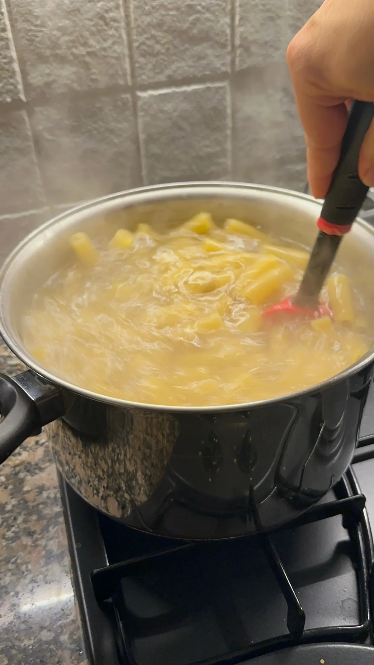 Pasta hirviendo en la olla, soltando el almidón que liga la salsa